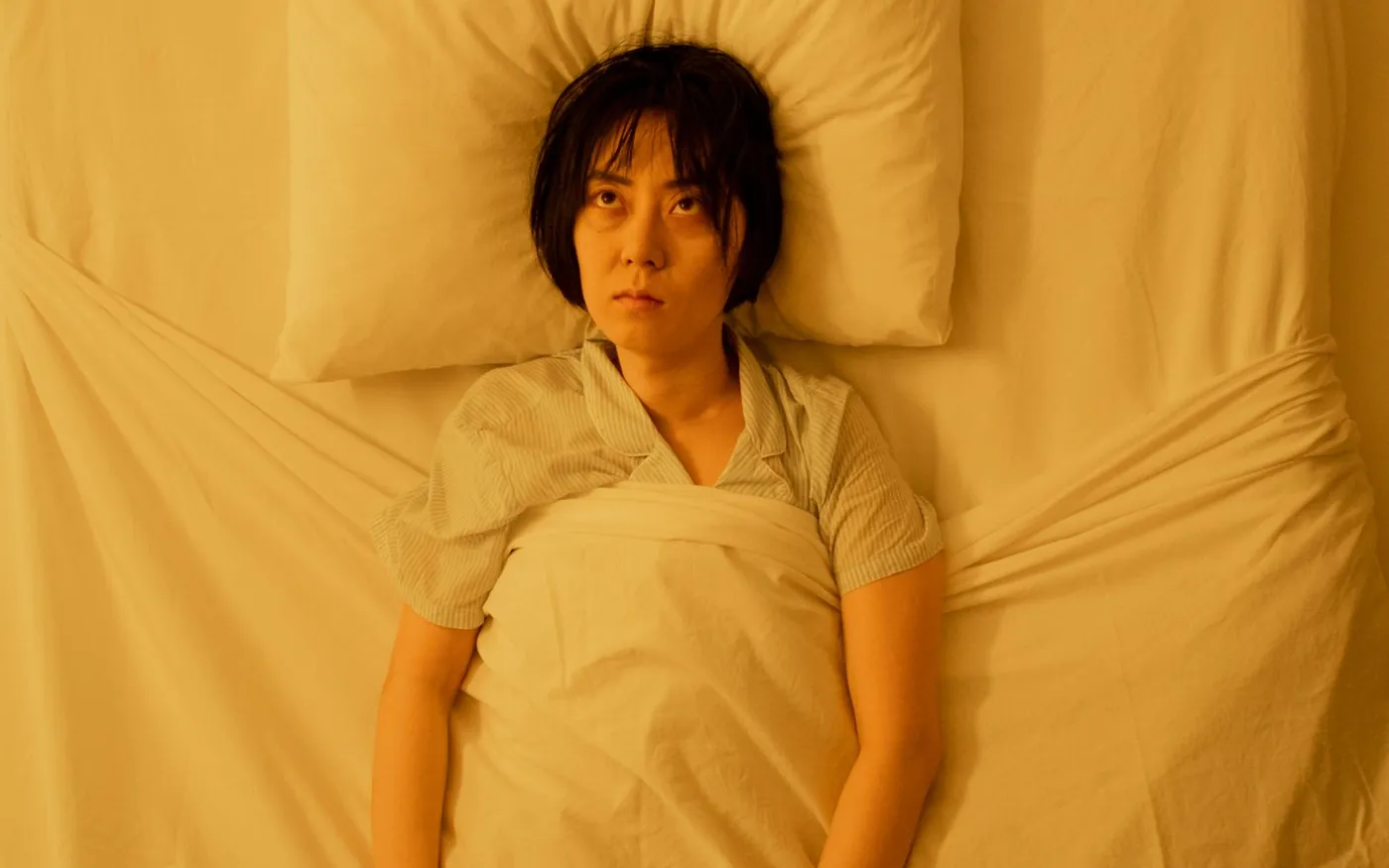 Woman awake in bed at night after waking up sweating